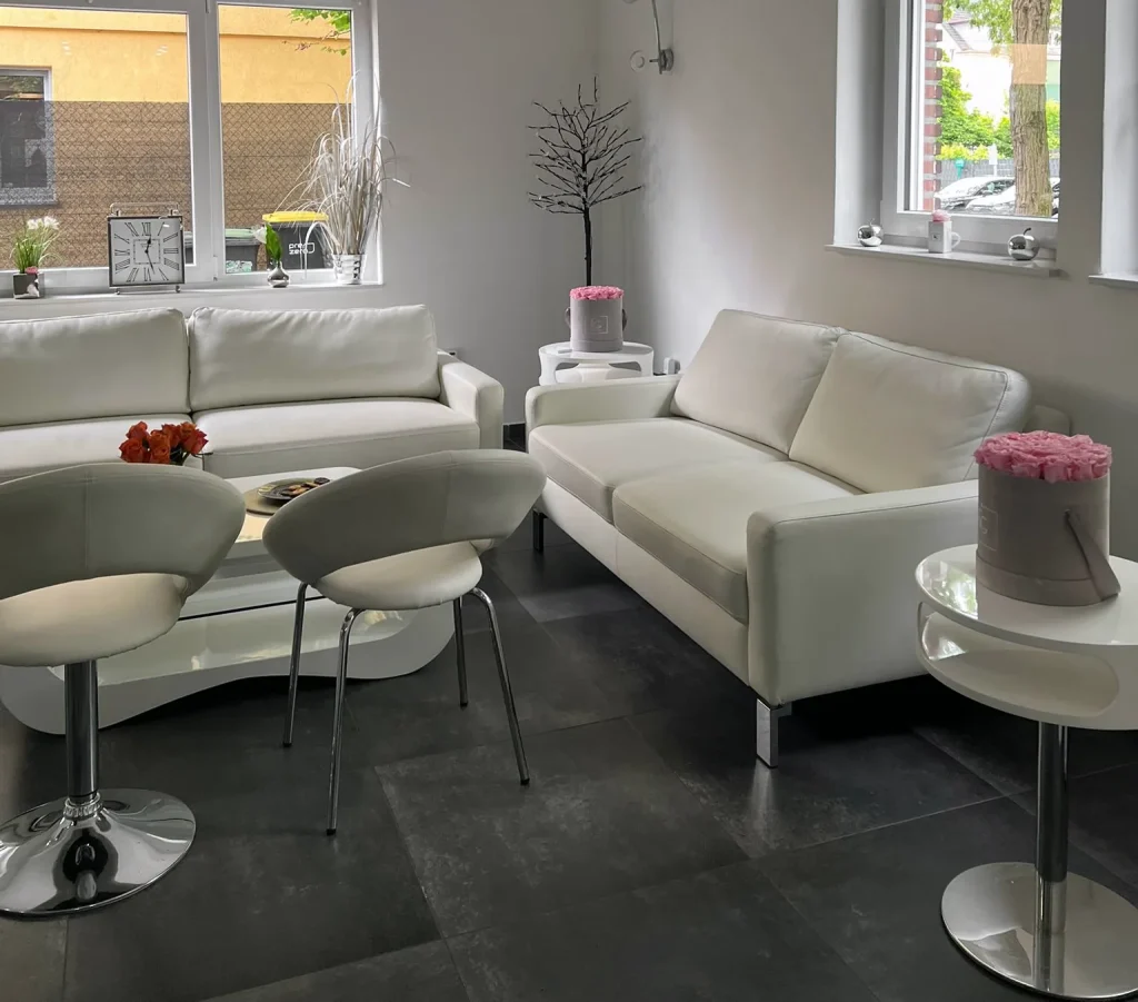 Lounge mit weißem Sofa und rundem Tisch am Standort Gütersloh